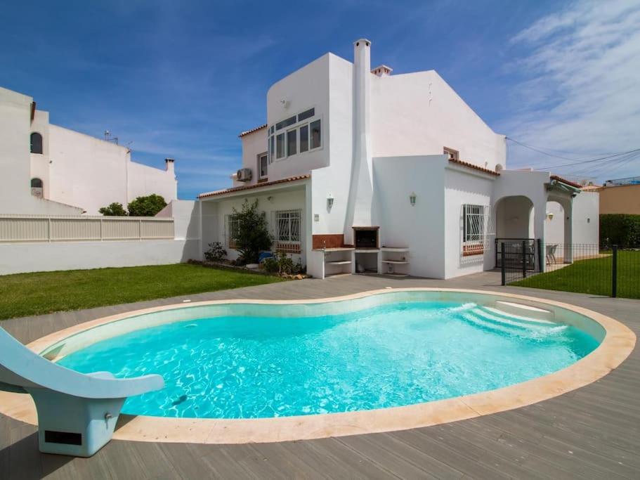 a villa with a swimming pool in front of a house at Villa Double Joy - Privacy & Privat Pool & Garden & Top Location & Albufeira in Albufeira