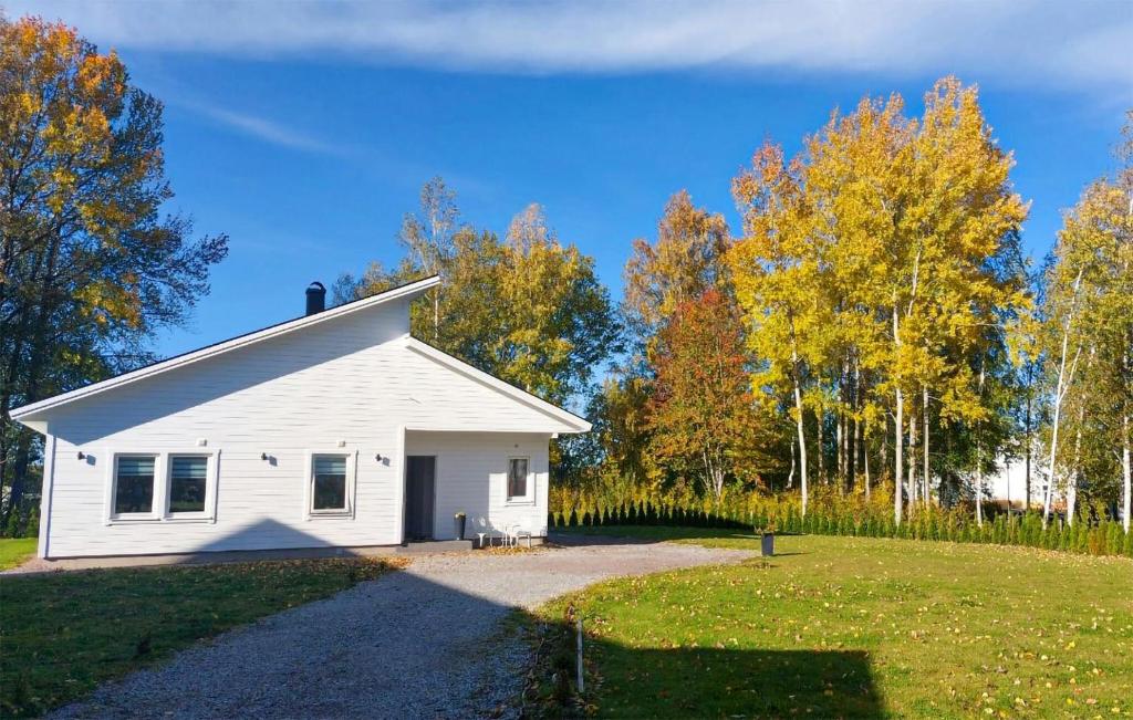 a white house with a driveway in a field at Lovely Home In Kumla With Kitchen in Kumla