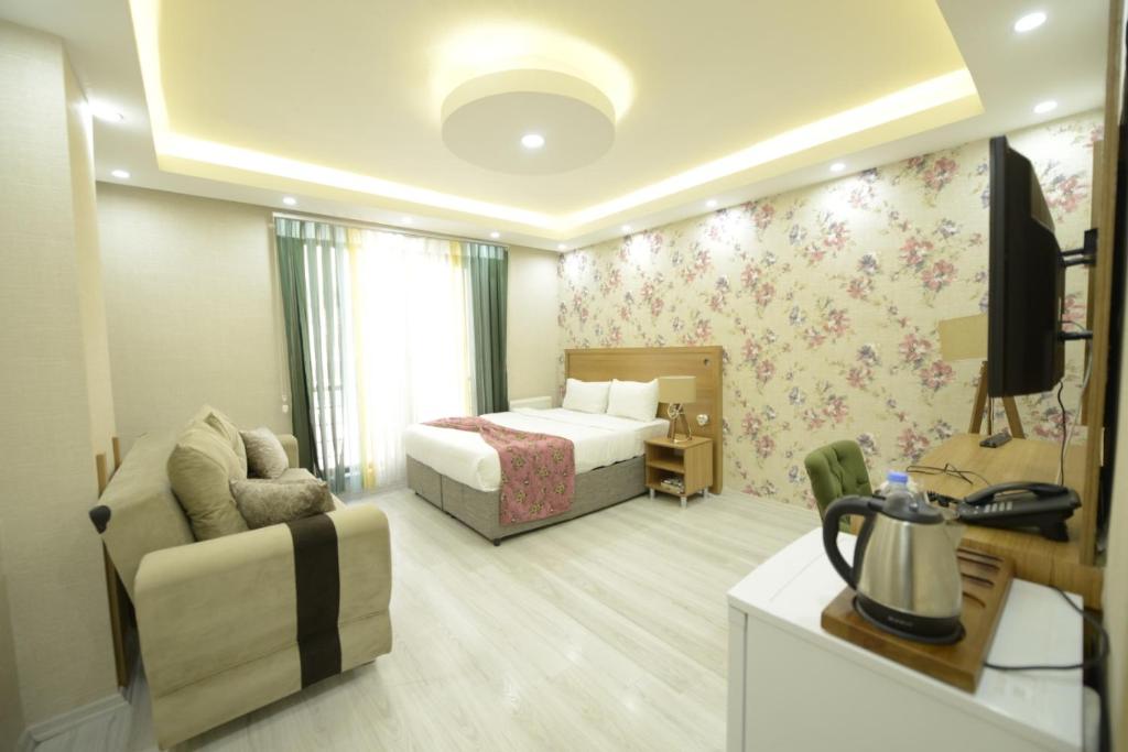 Habitación de hotel con cama y sofá en ADA LİFE SUİT HOTEL VAN en Bostaniçi