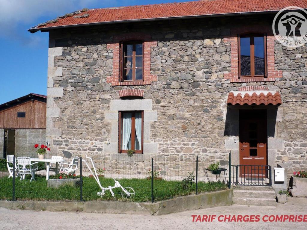 a stone house with a table and chairs in front of it at Gîte Saint-Héand, 2 pièces, 2 personnes - FR-1-496-144 in Saint-Héand