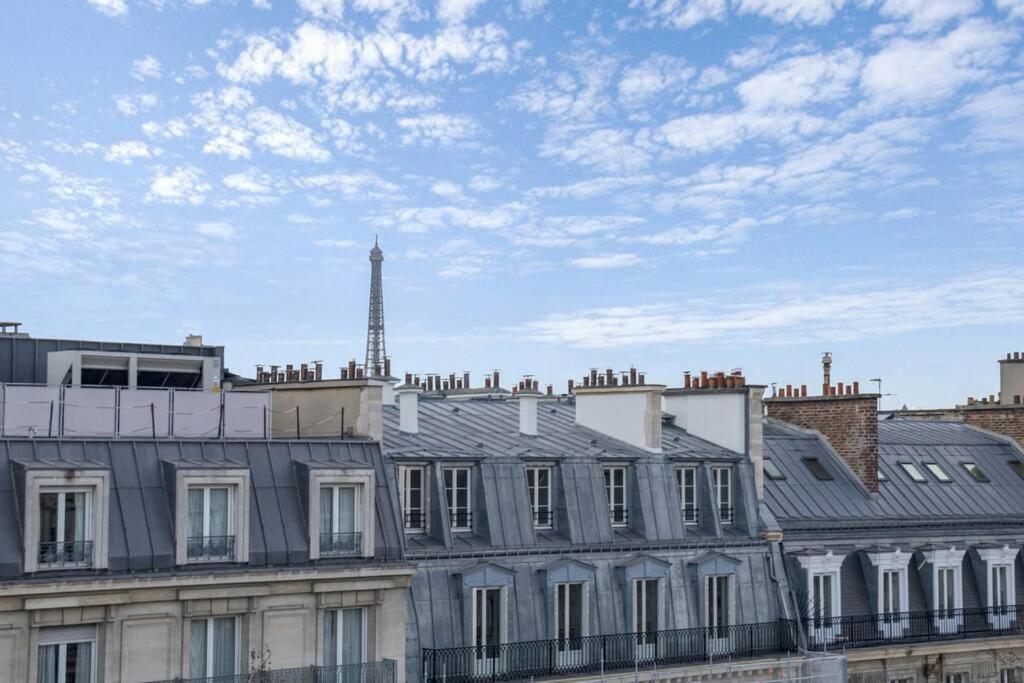 een uitzicht op een gebouw met een toren op de achtergrond bij 1 Bedroom#Haussmann#Amazing view#EffeilTower#AC in Parijs