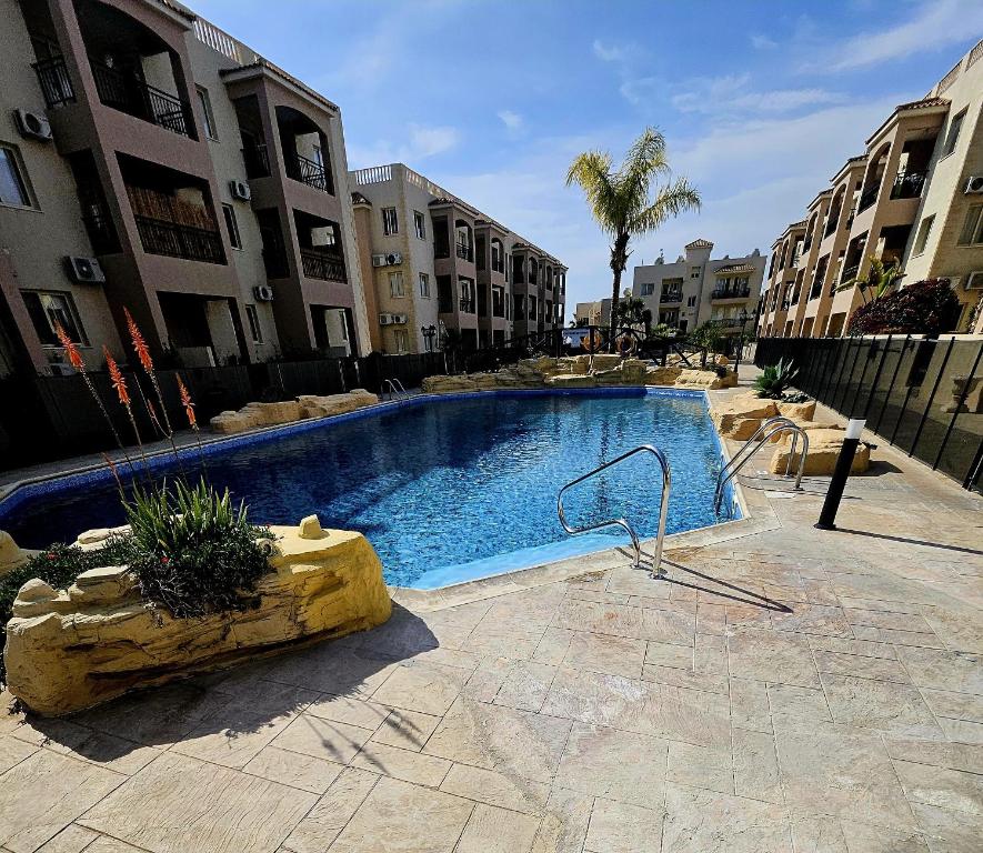una gran piscina en medio de un edificio en Delightful Poolside apartment, en Pafos