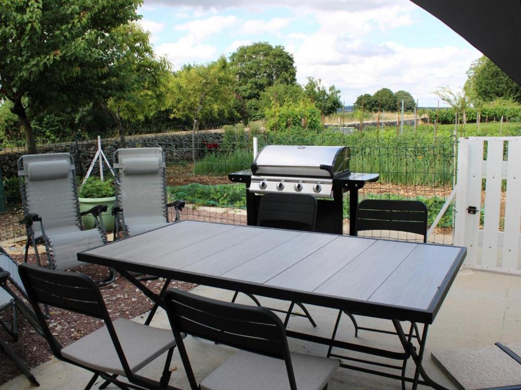 - une table de pique-nique avec un grill dans l'arrière-cour dans l'établissement Charmante maison de plain-pied avec cour privée, proche de Verteuil-sur-Charente, WiFi, plancha, parking - FR-1-653-106, à Verteuil-sur-Charente