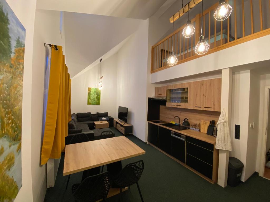 a kitchen and living room with a table and a couch at Apartmán - Dovolená Mladé Buky in Mladé Buky