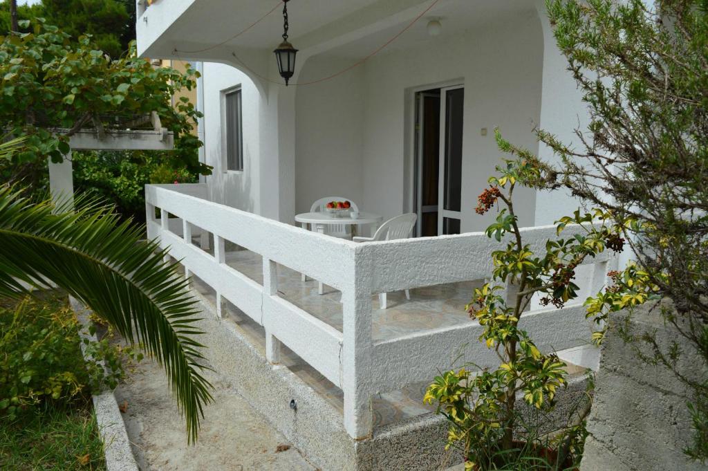 a porch of a white house with a table at Apartment Zeleny Pojas in Bar