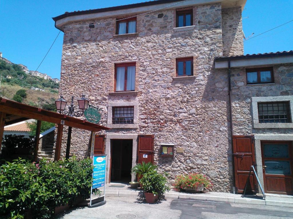 un bâtiment en pierre avec un panneau en face de celui-ci dans l'établissement Hotel Ristorante Antica Marina, à Nicotera Marina