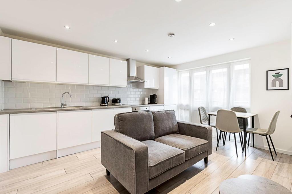 a kitchen and living room with a couch and a table at Finsbury Park Retreat Modern Comfort in London