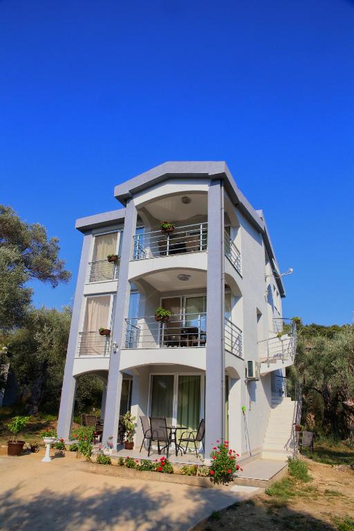 a white apartment building with a balcony and flowers at Nana Dea 2 in Utjeha