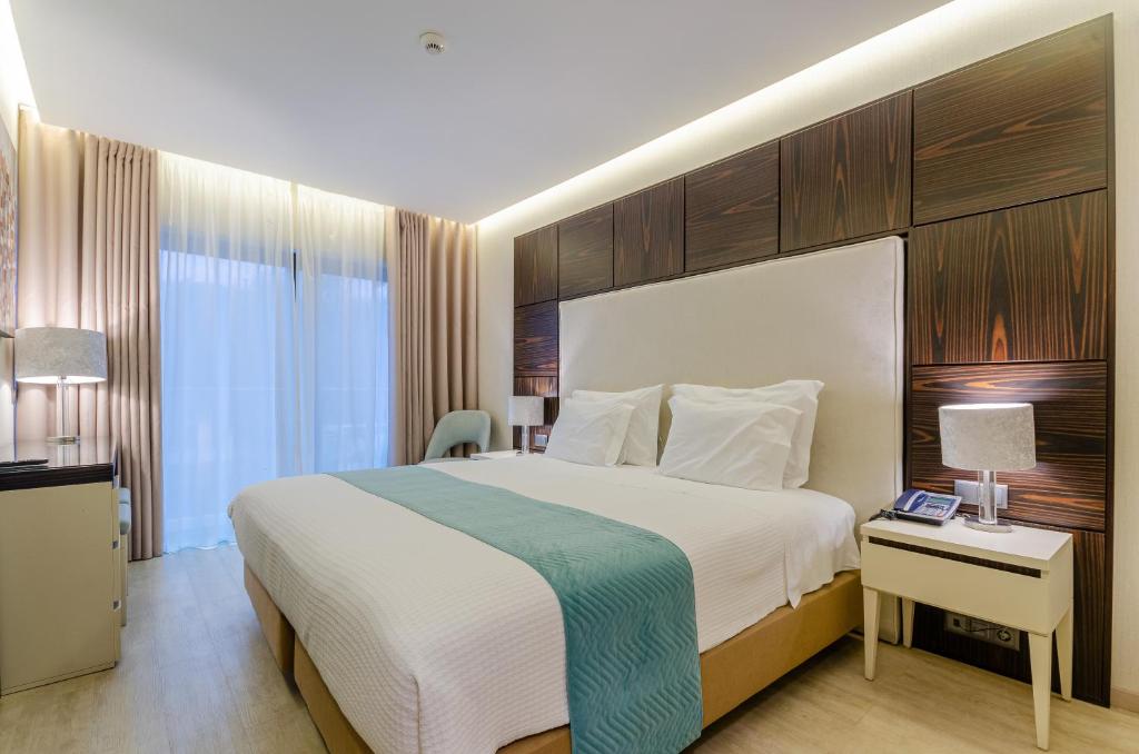 Habitación de hotel con cama grande y escritorio. en Hotel Alvorada en Estoril