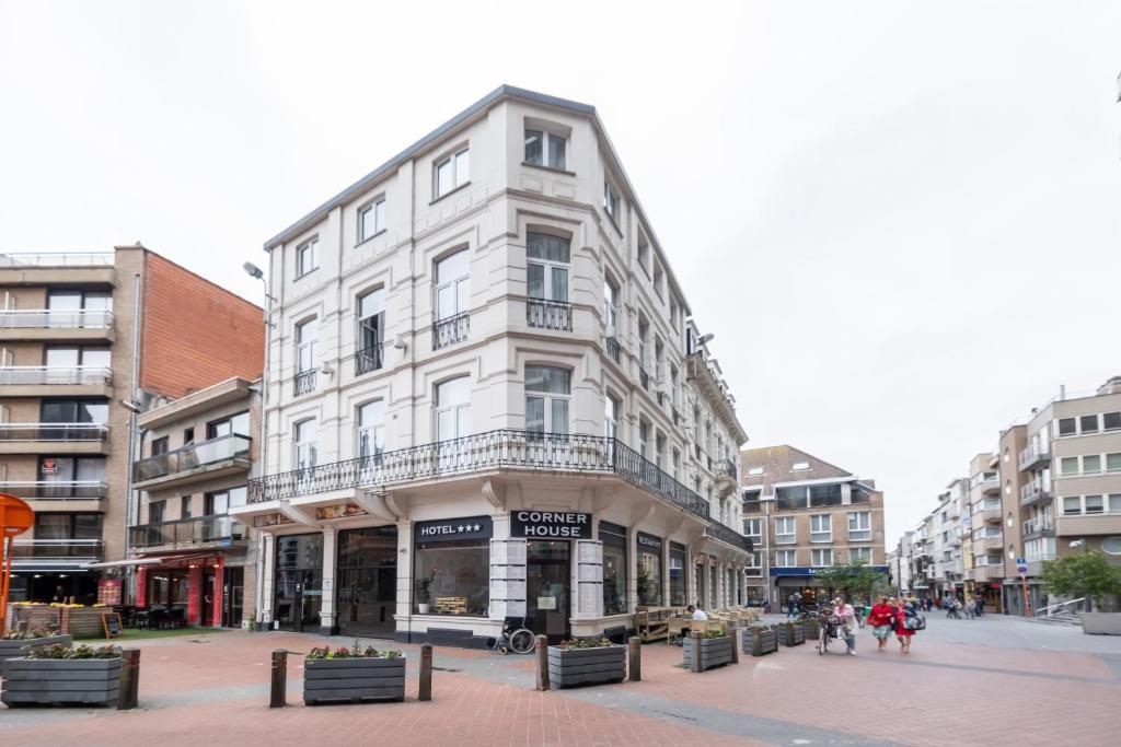 a white building on the corner of a street at Hotel Corner House by WP Hotels in Blankenberge