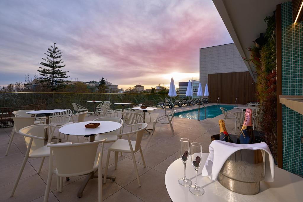 un patio con mesas y sillas y una piscina en Óbal Urban Hotel en Marbella