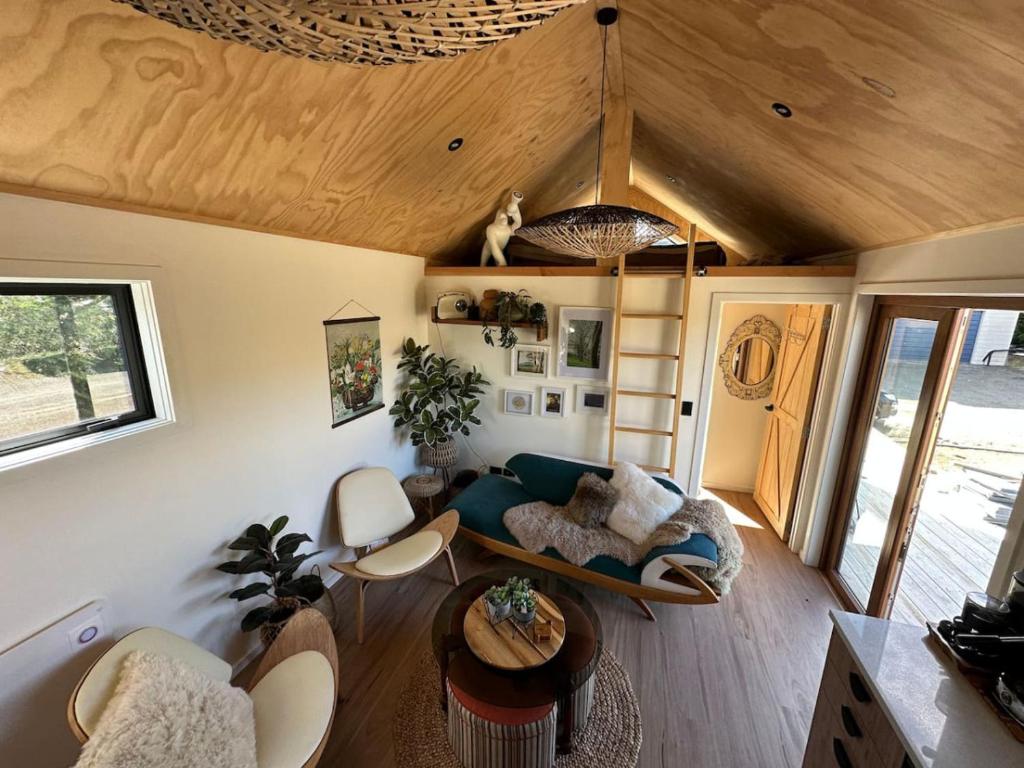 a living room with a couch and a table at Petite Perfection tiny house at Lake Hawea in Lake Hāwea