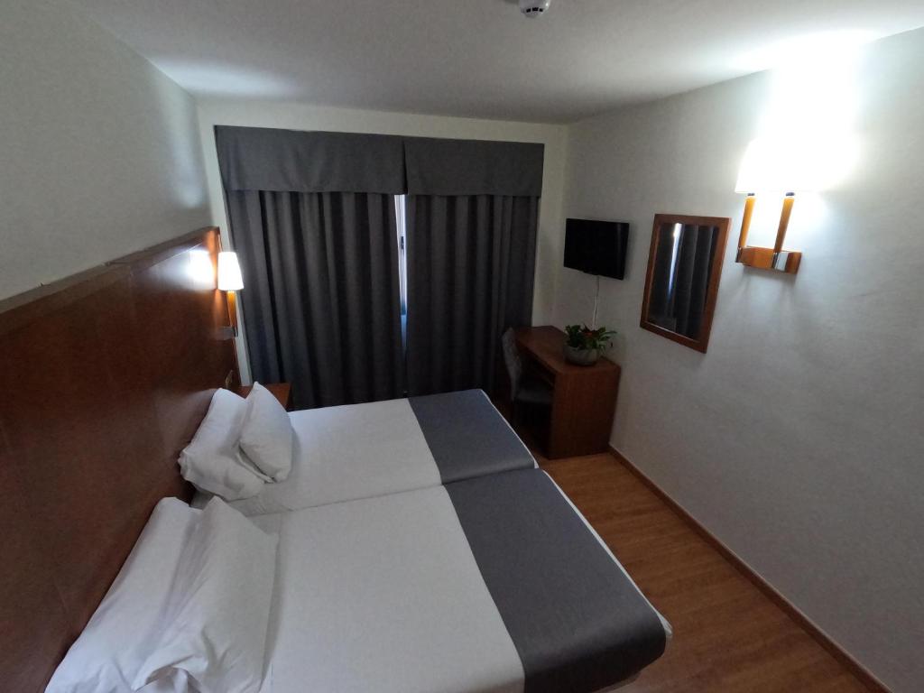 a hotel room with a bed and a window at Hotel Saylu in Granada