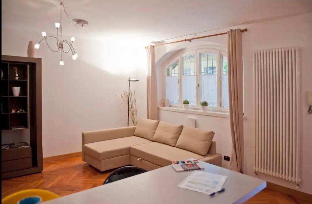 een woonkamer met een bank en een tafel bij Tricolore - Sottocorno Charme Loft in Milaan