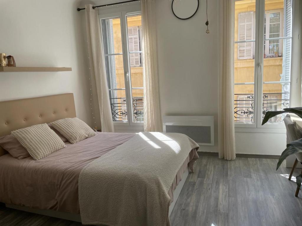 une chambre avec un lit et deux fenêtres dans l'établissement Studio Aix Centre Historique, à Aix-en-Provence