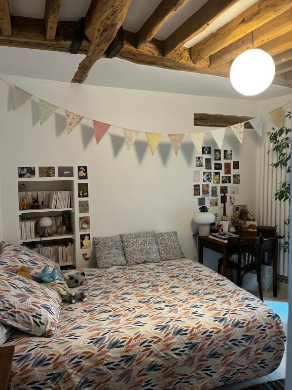 - une chambre avec un lit et une table avec un bureau dans l'établissement Deux chambres en plein cœur de Montmartre, Paris, à Paris