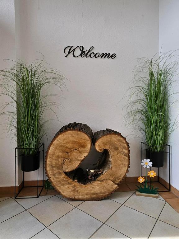 a large wooden pretzel sitting on a floor with two plants at Gästehaus Bad Dürrenberg in Bad Dürrenberg
