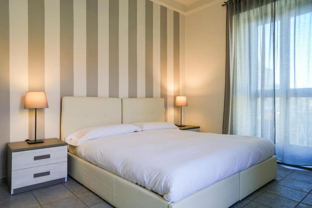 um quarto com uma cama com 2 candeeiros e uma janela em Montalto House em Turim