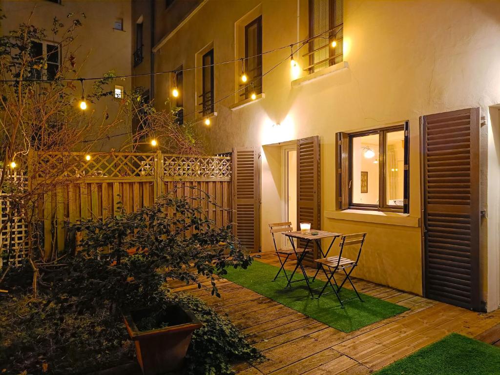 クリシーにあるPeaceful apartment with private gardenのパティオ(テーブル、椅子、フェンス付)