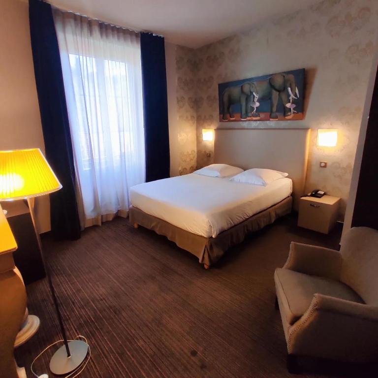 a hotel room with a bed and a chair at Hôtel de Paris in Besançon