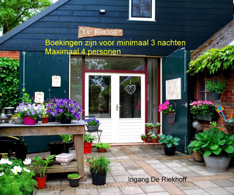 una puerta de entrada de una floristería con macetas en De Riekhoff, en Een-West