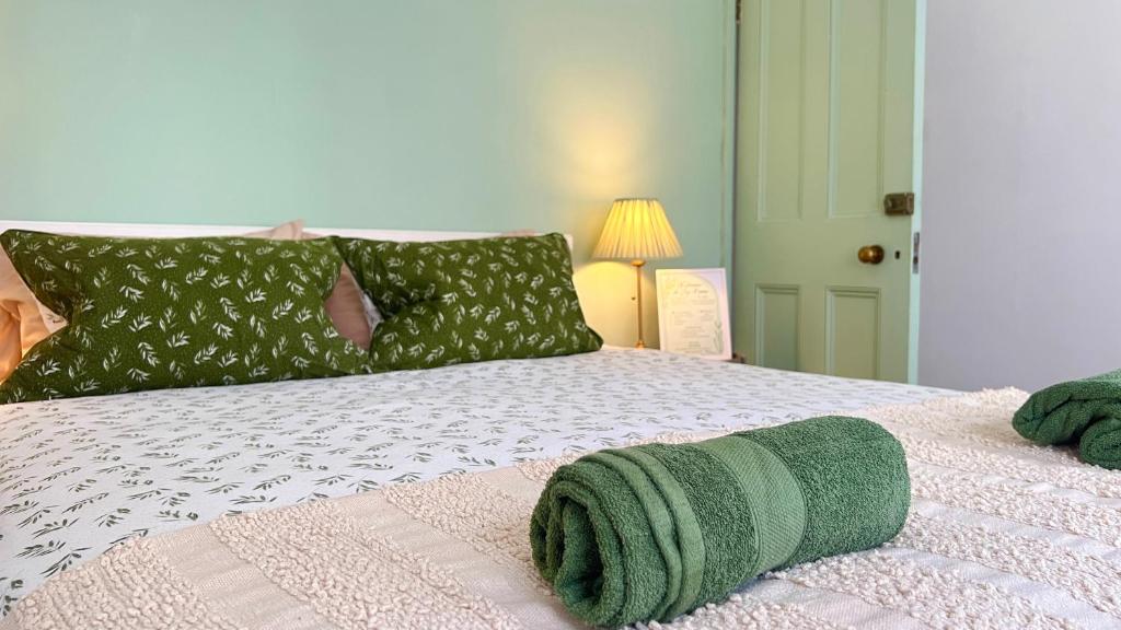 ein Schlafzimmer mit einem Bett mit grünen Handtüchern darauf in der Unterkunft Westminster Apartment in London
