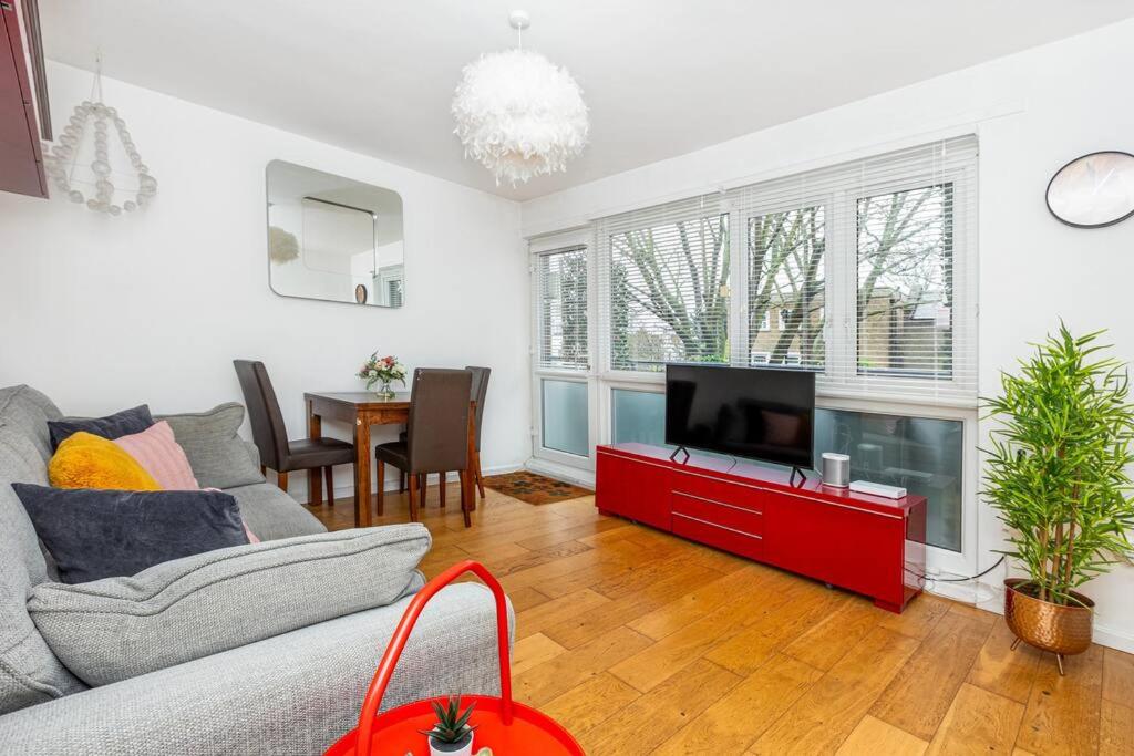 a living room with a couch and a tv at Newly refurbished 2BR wbalcony in Vibrant Peckham in London