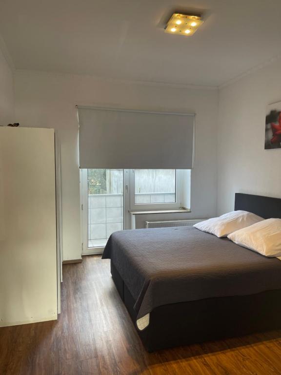 a bedroom with a large bed and a window at Düs Apartment 2 in Düsseldorf