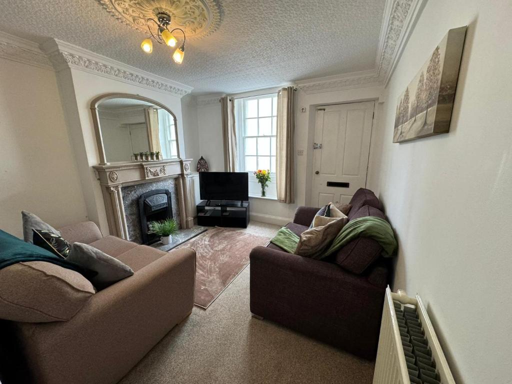 sala de estar con 2 sofás y chimenea en Scotch Terrace - 3 Bed House, en Whitehaven