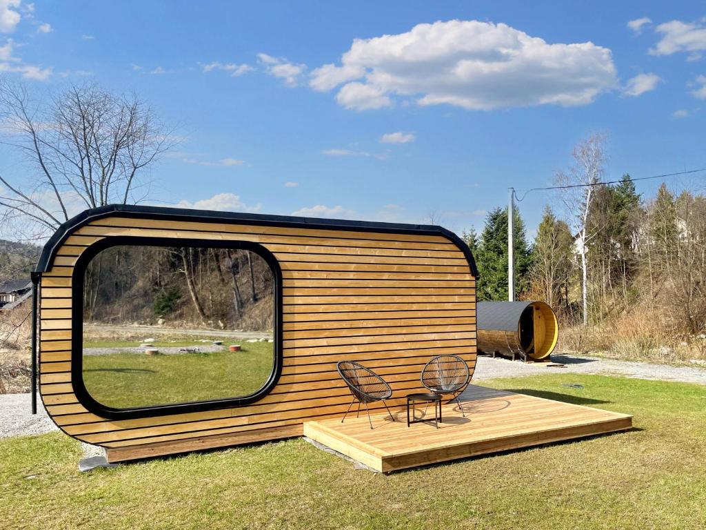 ein kleines Haus mit einem Spiegel und zwei Stühlen in der Unterkunft Domček Artemis in Zuberec