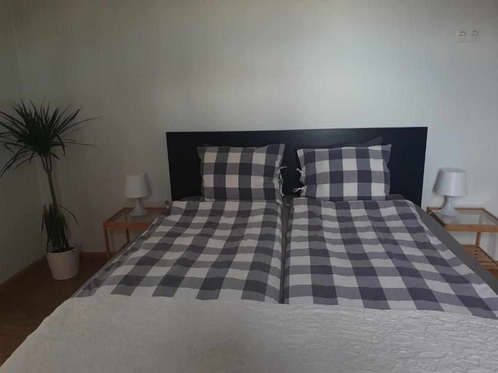 a bed with a black and white checkered blanket and pillows at Vorsabær Apartment in Selfoss