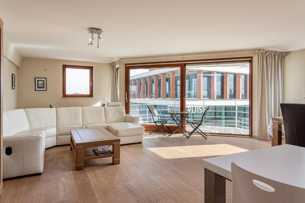 uma sala de estar com um sofá branco e uma grande janela em Harbour View 2a 2ev em Zeebrugge