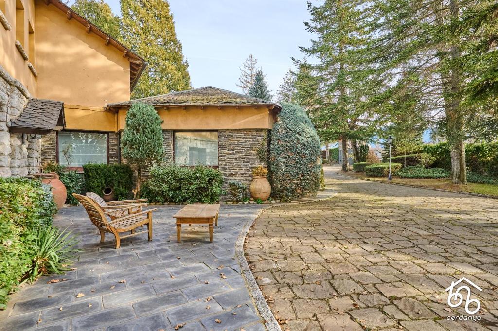 a house with a patio with a bench and a table at Casa Torre de les Àligues in Bellver de Cerdanya 