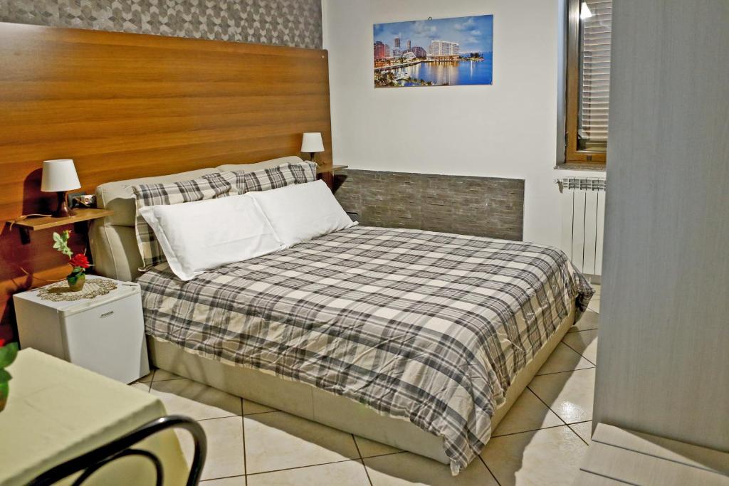 1 dormitorio con 1 cama con manta a cuadros en Villa Nancy Affittacamere, en Cimitile