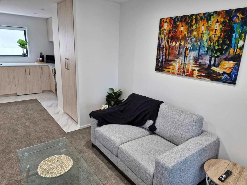 a living room with a couch and a painting on the wall at Salisbury Apartments 8 in Christchurch
