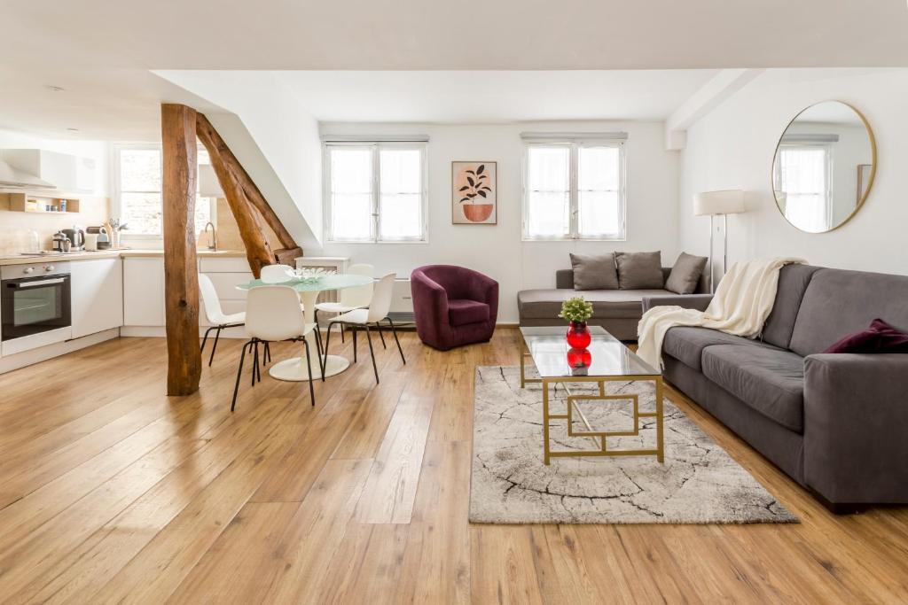 un salon avec un canapé et une table dans l'établissement Artois Champs-Elysées with AC, à Paris