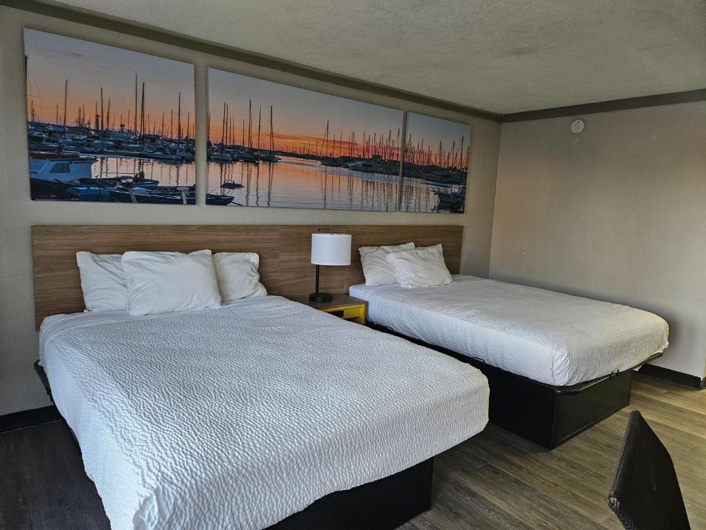 2 Betten in einem Hotelzimmer mit Gemälden an der Wand in der Unterkunft Days Inn by Wyndham Washington in Washington