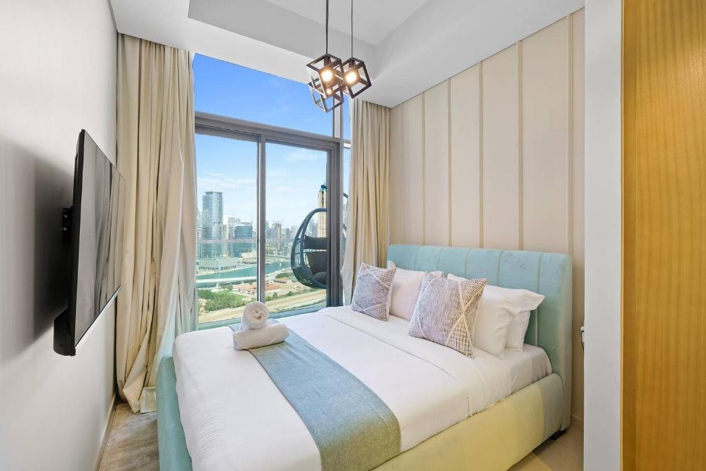 ein Schlafzimmer mit einem Bett und einem großen Fenster in der Unterkunft High-floor 2br In Aykon City Spacious, Good View in Dubai