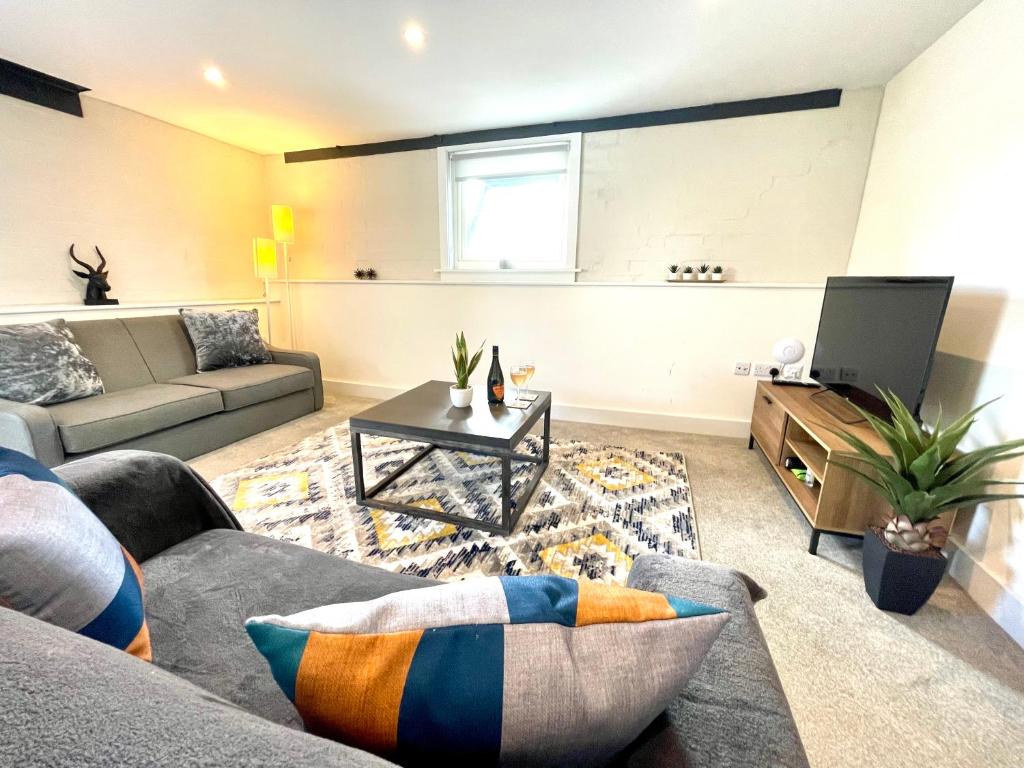 a living room with a couch and a tv at New Executive Apartment Perfect for Contractors & Pilots in Bishops Stortford