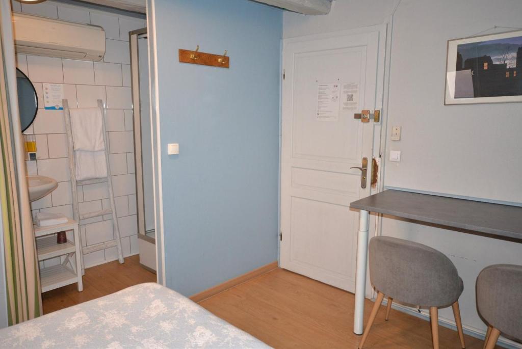 a room with a bed and a table and a door at Chambres d&#39;hôtes Chez Caroline in Colmar