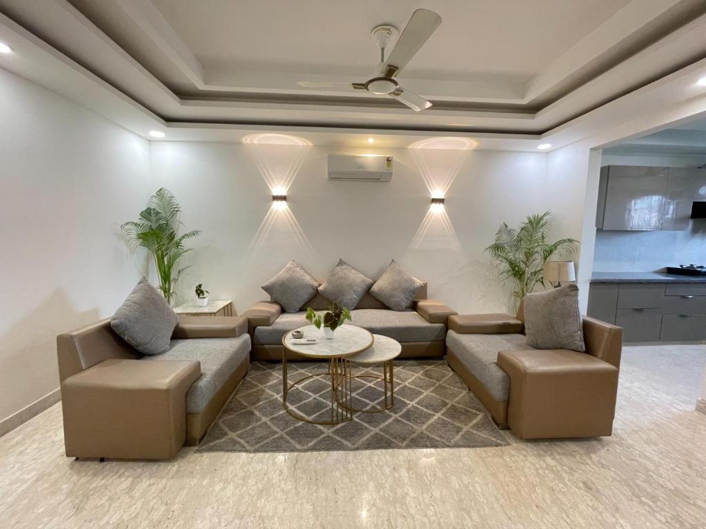 uma sala de estar com um sofá e uma mesa em Bedchambers Serviced Apartments, Ardee City em Gurgaon