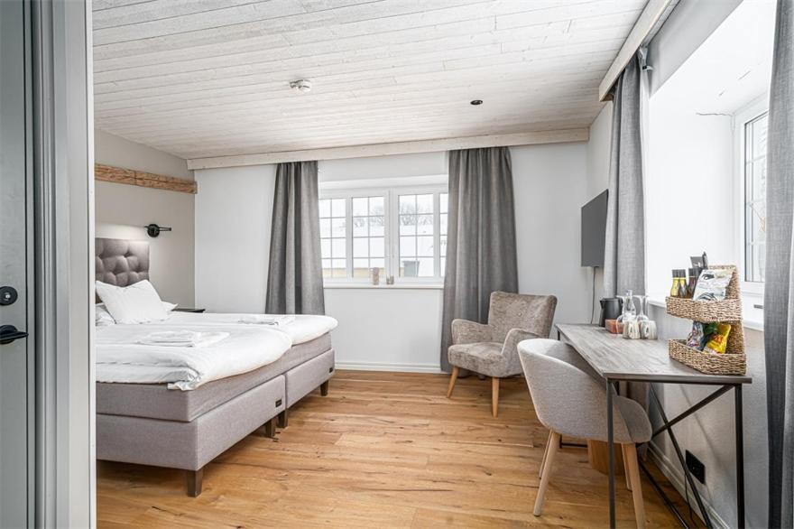 een slaapkamer met een bed, een bureau en een stoel bij Elisefarm in Fogdarp