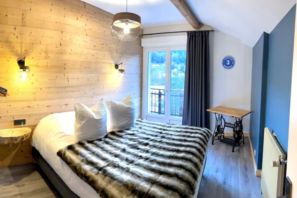 a bedroom with a bed with a wooden wall at Le Barbapou in Ventron