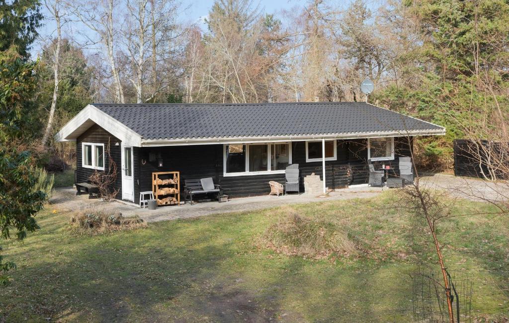 een zwart huis met een veranda en een tuin bij 3 Bedroom Gorgeous Home In Rrvig in Rørvig