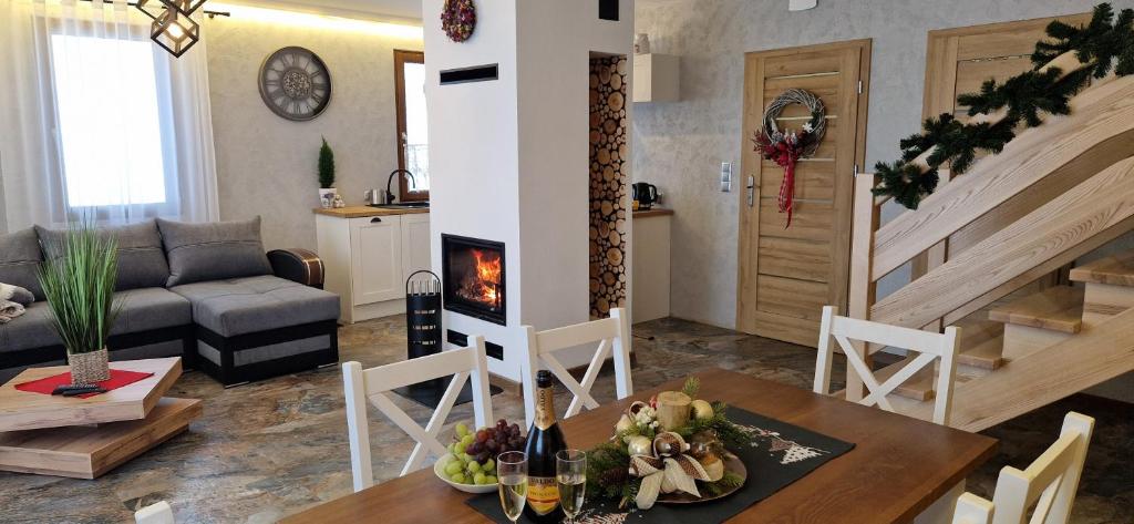 ein Wohnzimmer mit einem Tisch und einem Kamin in der Unterkunft Domki 4 pory roku in Koniaków