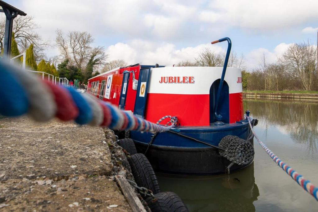 a boat tied up to a dock on a river at The Jubilee Narrow Boat in Loughborough