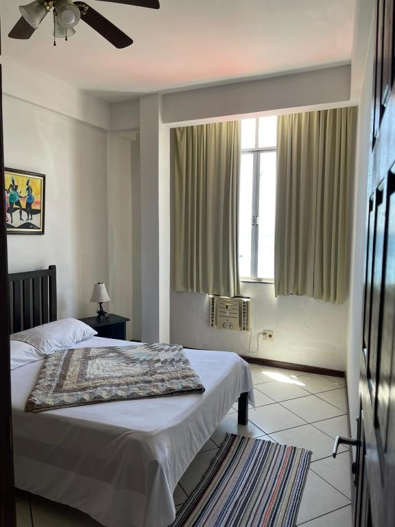 a bedroom with a bed and a ceiling fan at Manga Rosa Suites in Salvador