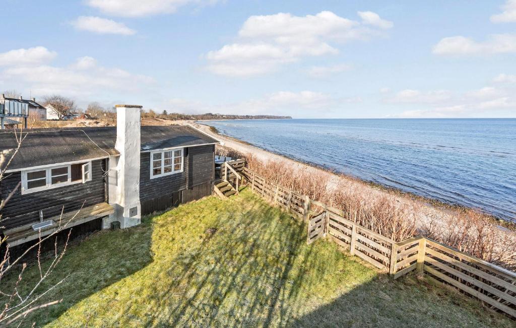 a house on the shore of a body of water at Beautiful Home In Dronningmlle With House Sea View in Dronningmølle