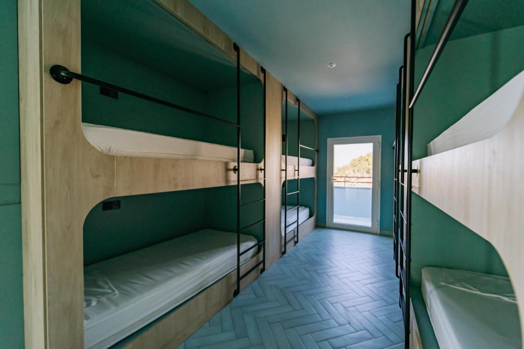 um quarto com 2 beliches e uma banheira em The Boc Hostels - Beach em Can Pastilla