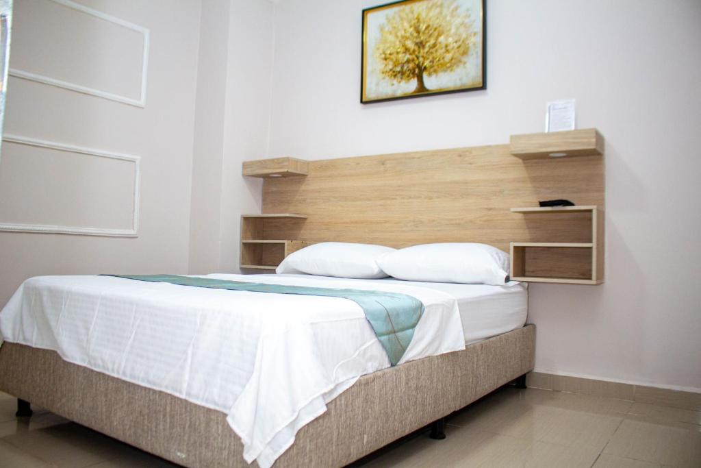 a bedroom with a large bed with a wooden headboard at Hotel Horizon In in Santa Marta